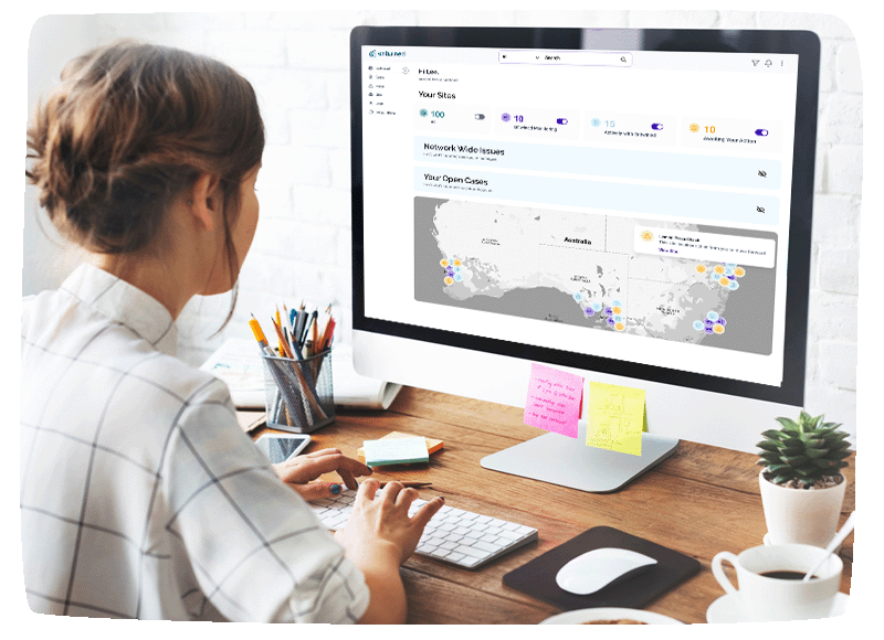 A girl sitting at a desk, working on her computer with MyEntwined Dashboard on screen