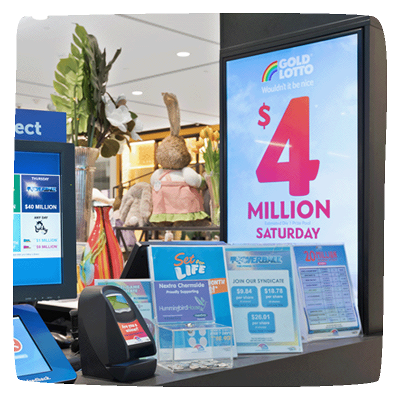 A news agency shopfront desk, with various lotto posters. Digital Screen displaying a jackpot and a computer screen showing all of the jackpots. 